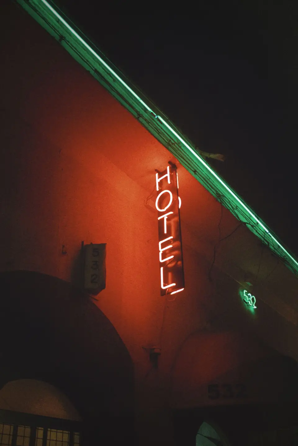 Enseigne lumineuse « HÔTEL » de nuit — transfert taxi hôtel depuis Bourgoin-Jallieu